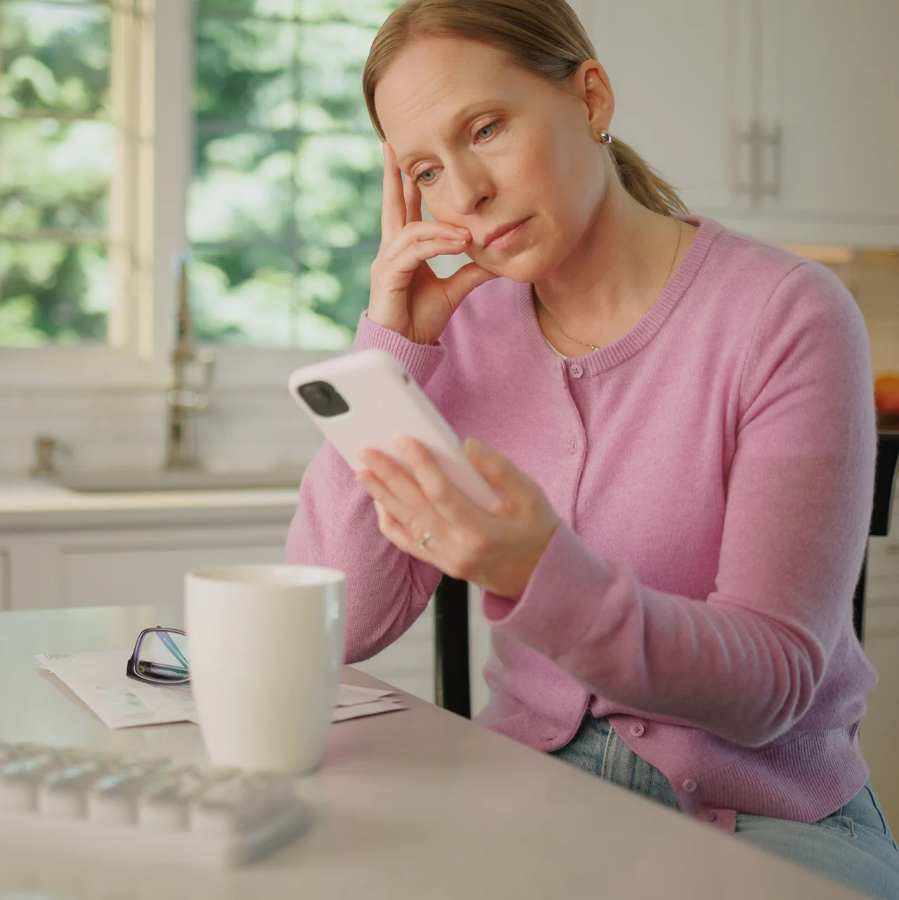 Woman on her phone researching chronic HypoPARAthyroidism